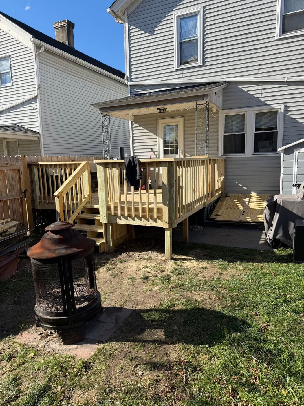 Small back deck with stairs and new basement doors, view 2