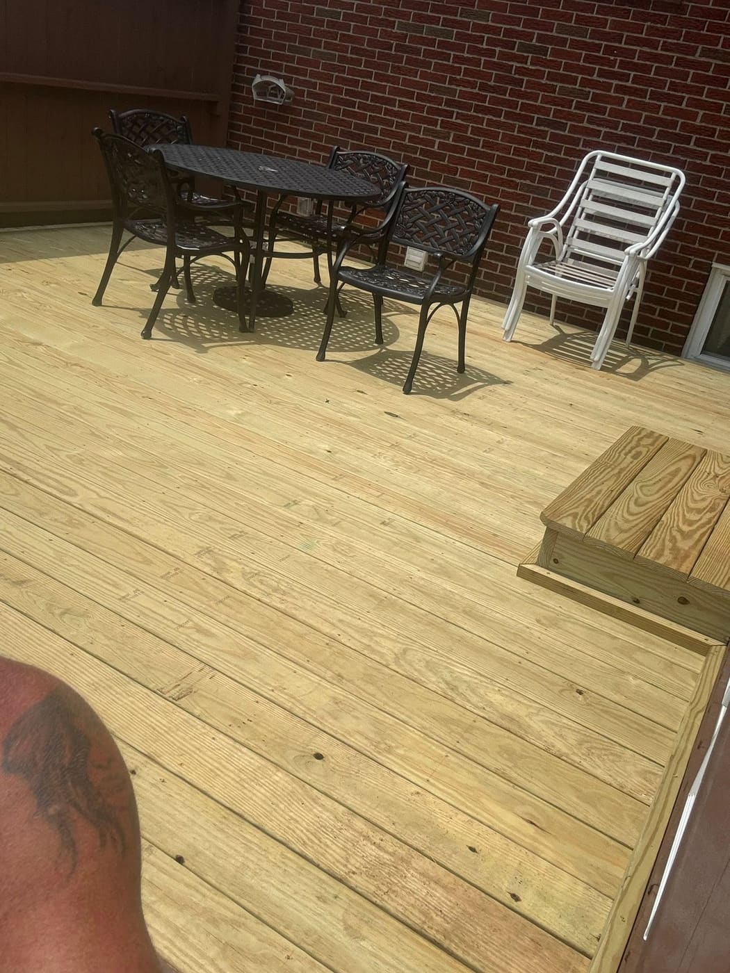 Rebuilt pressure-treated deck with patio furniture