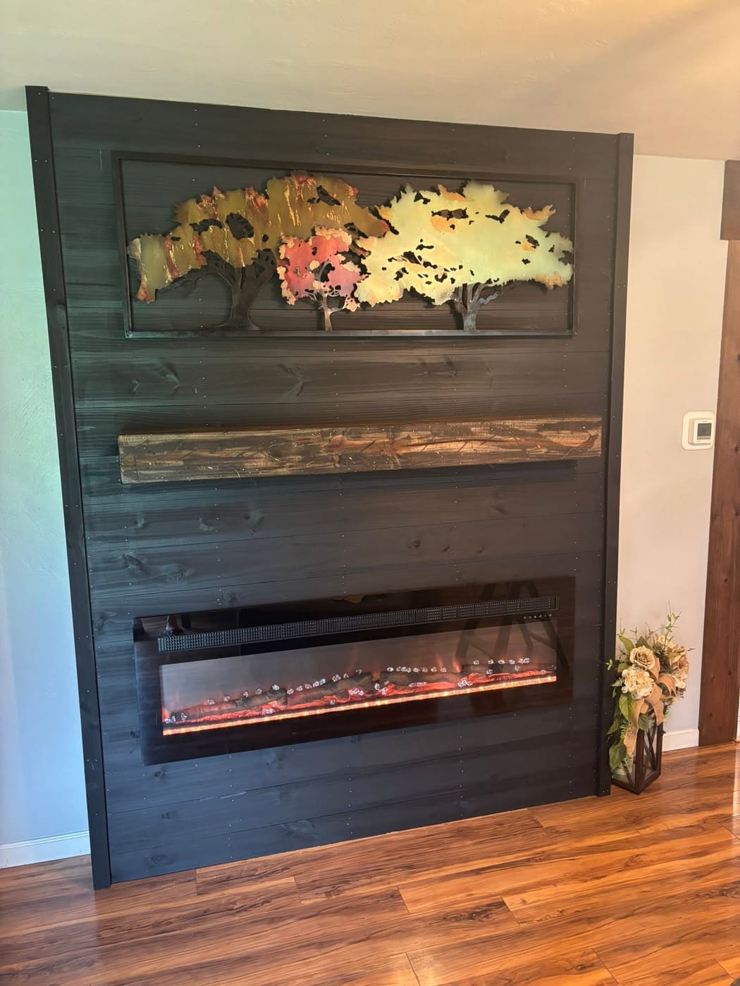 Dark plank accent wall with electric fireplace and mantel