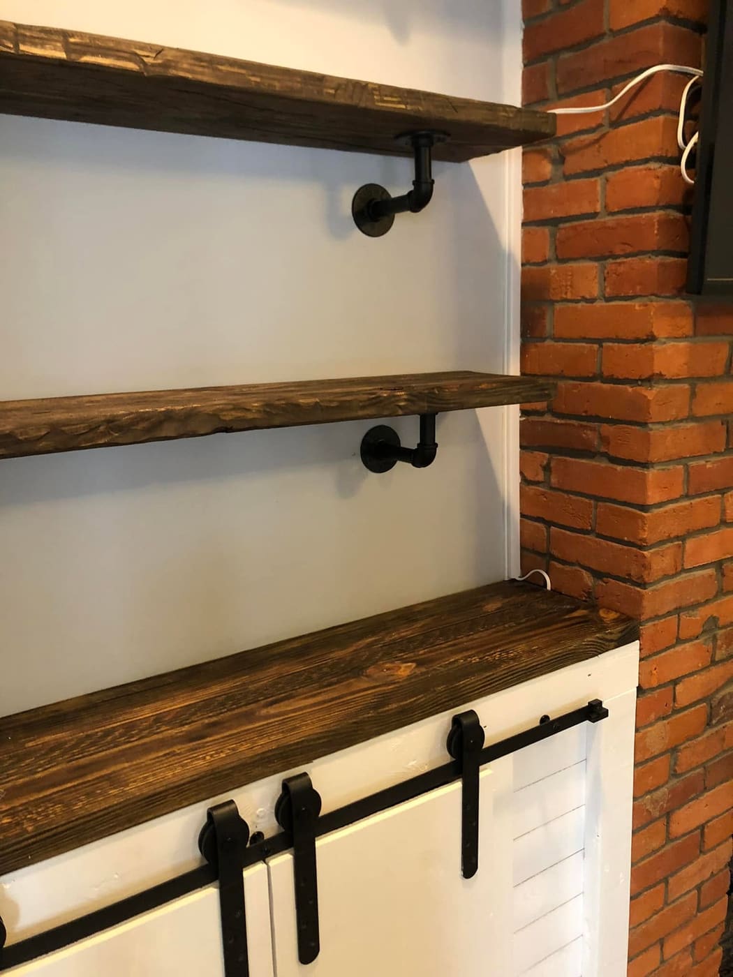 Built-in cabinets and shelves beside a brick fireplace