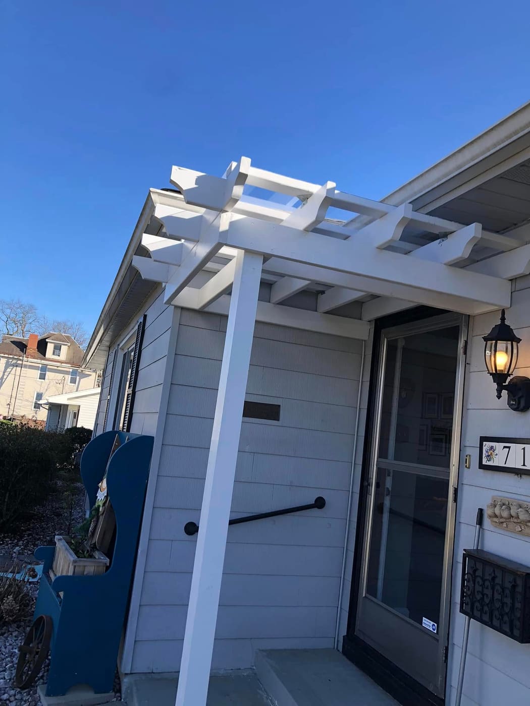 White pergola over a front entry, view 2