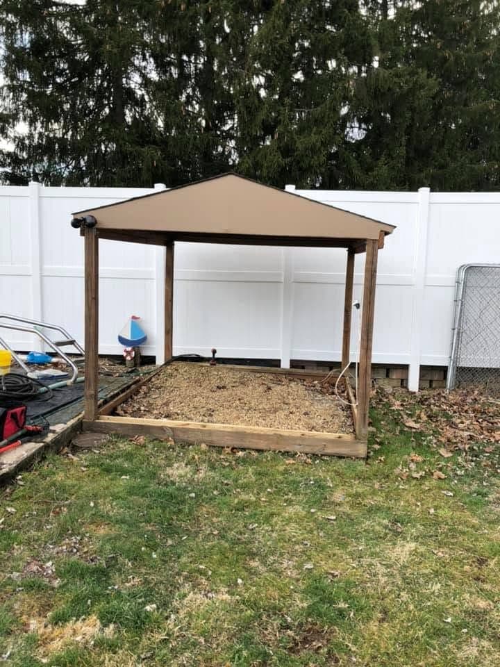Wood tiki bar and gazebo in a fenced backyard
