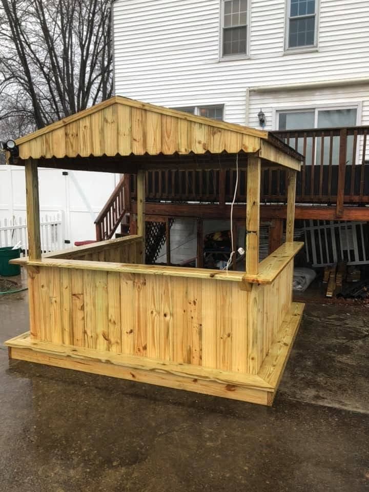 Wood tiki bar and gazebo in a fenced backyard, view 2