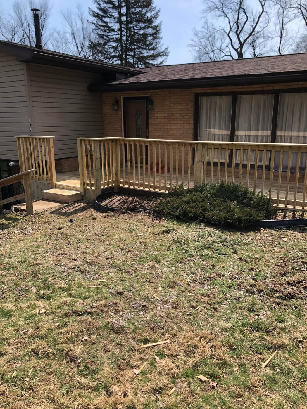 Low deck with railing along a house