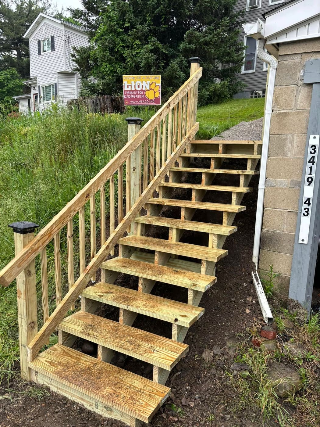 New wood stairs and railing up a hillside, view 2