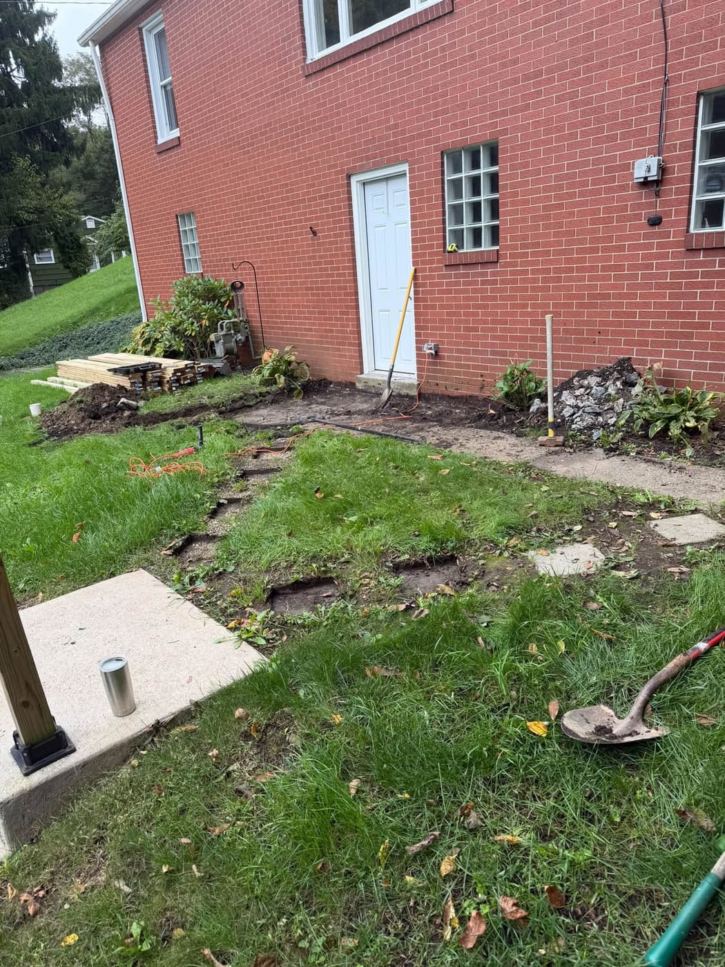 L-shaped pressure-treated walkway deck beside a brick house