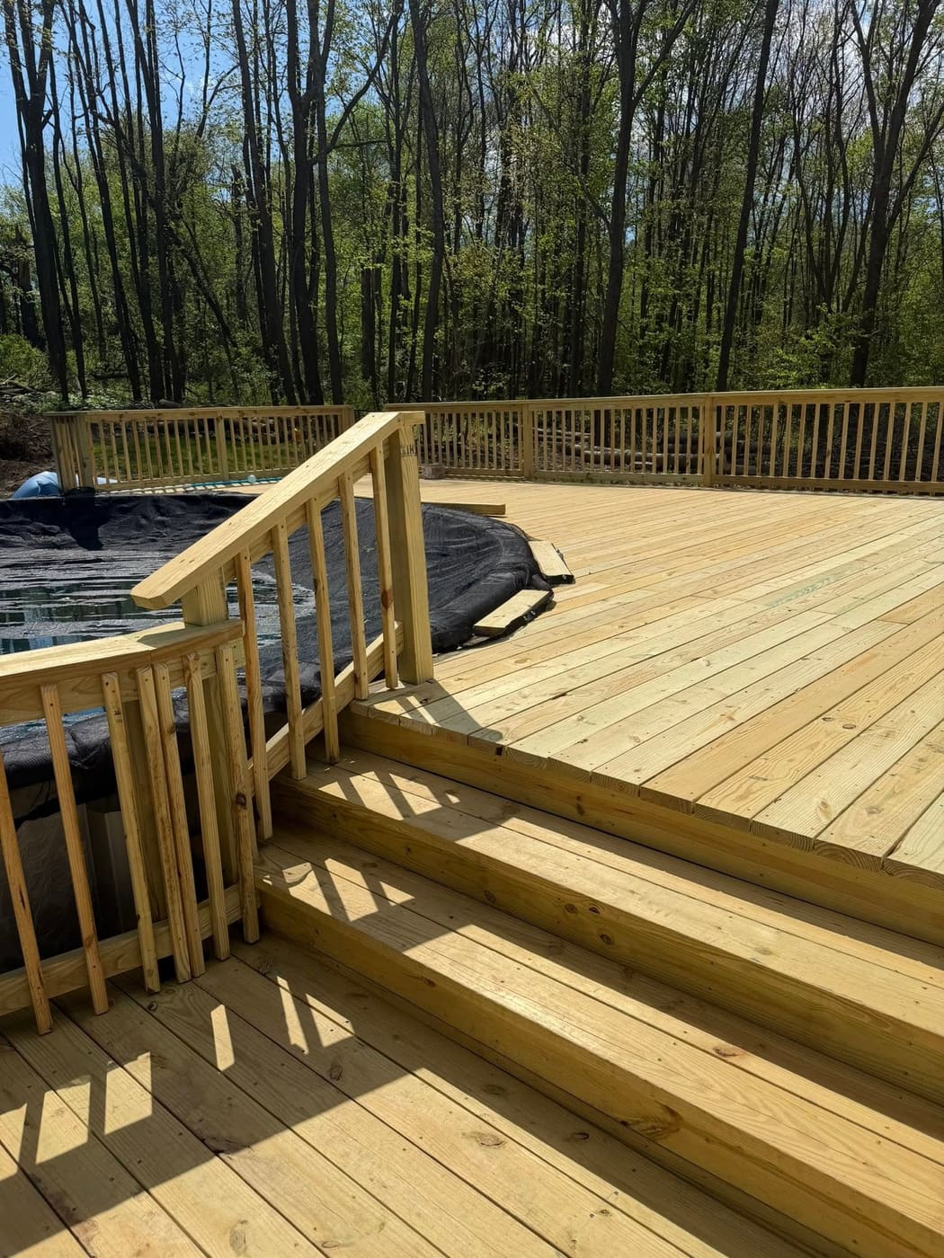 Large pressure-treated deck around an above-ground pool