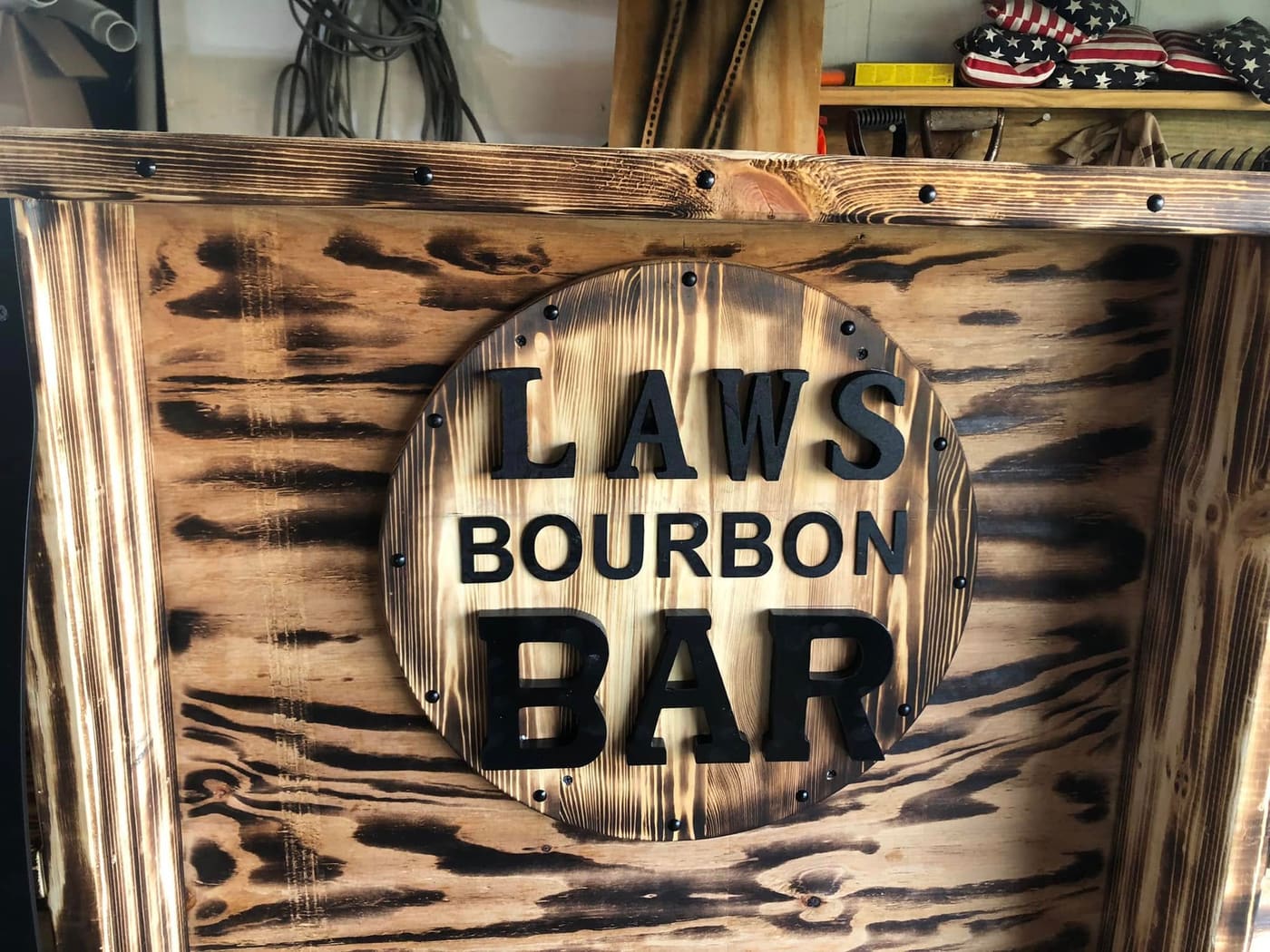 Burnt-wood basement bar with a carved Laws Bourbon Bar sign, view 10