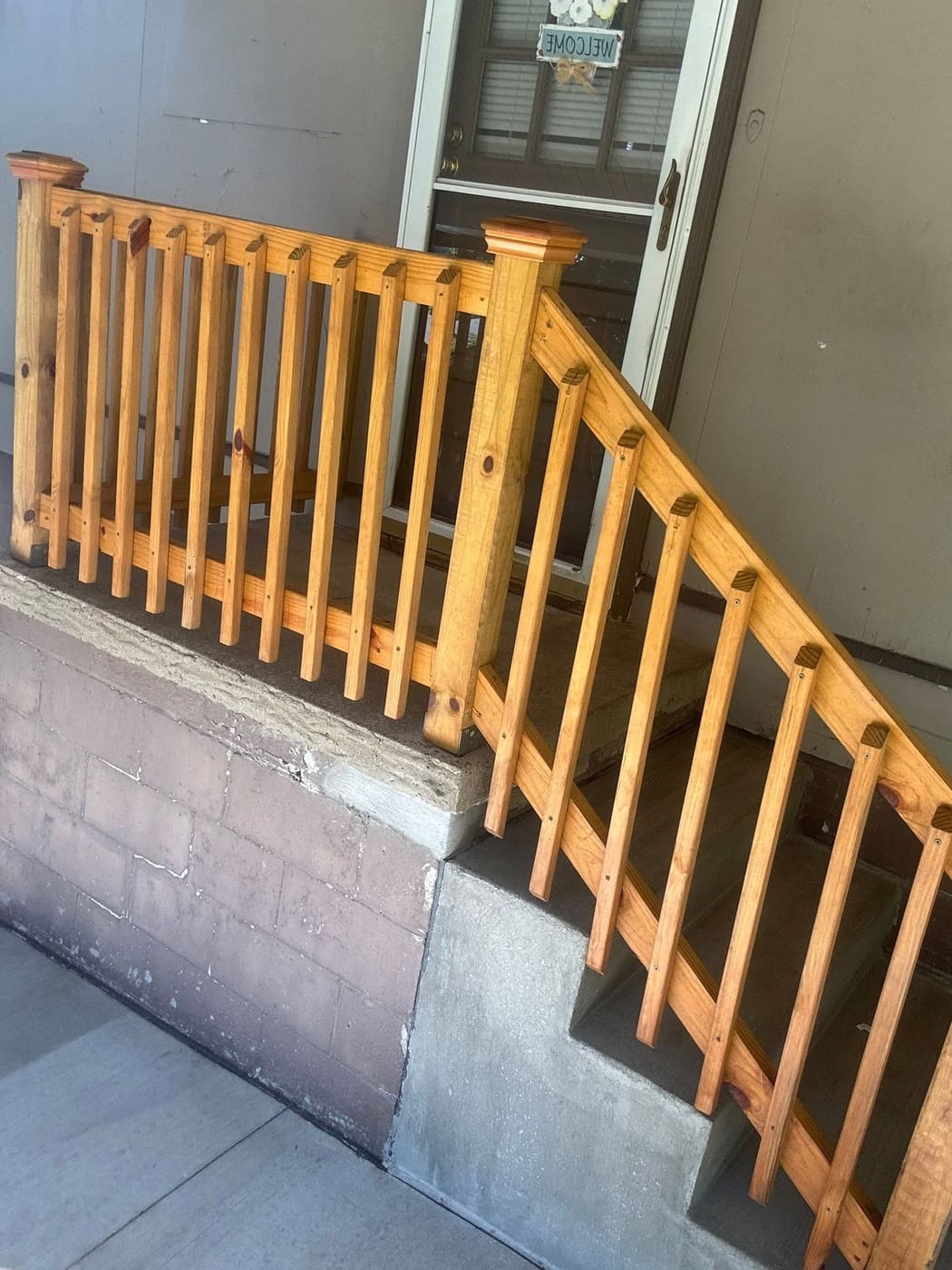 Stained wood stair railing beside garden steps
