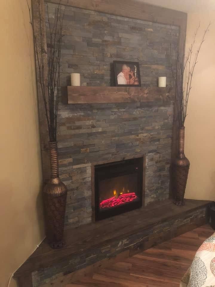 Stacked-stone electric fireplace with wood mantel